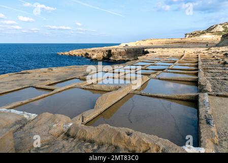 Sale pentole di evaporazione su Malta. Stagni vicino al mare riempita con acqua al giorno soleggiato, febbraio 2019 Foto Stock