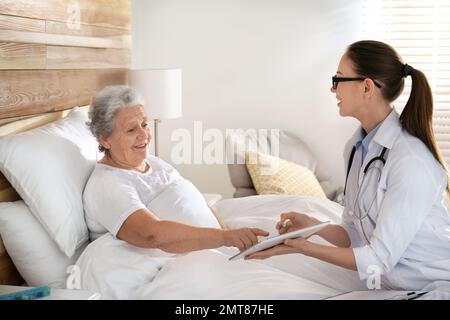 Medico che visita paziente anziano in ospedale moderno Foto Stock