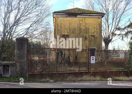 Complesso industriale abbandonato chiuso da un cancello nella campagna italiana Foto Stock