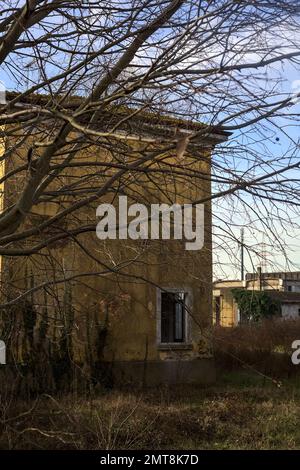 Complesso industriale abbandonato chiuso da un cancello nella campagna italiana Foto Stock