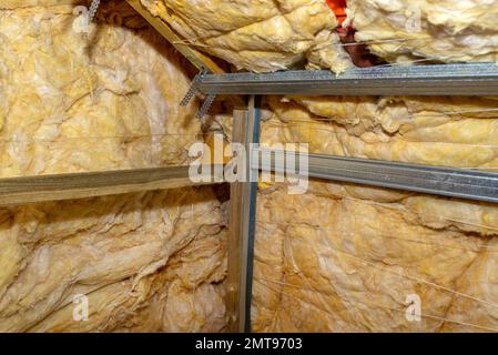 Telaio in alluminio con appendiabiti disposti su travi in soffitta per il montaggio di cartongesso. Foto Stock
