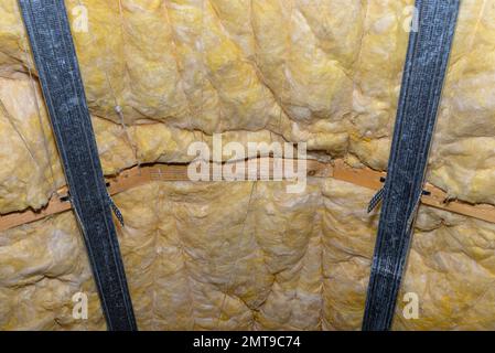 Telaio in alluminio con appendiabiti disposti su travi in soffitta per il montaggio di cartongesso. Foto Stock
