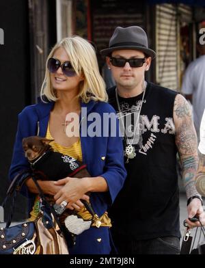 Una di queste cose non è come le altre! Paris Hilton, con il suo piccolo cane al traino, sembra un po' fuori posto con il suo abito colorato e il grande cappello blu mentre lei e il ragazzo Benji Madden fanno una sosta per fare shopping al negozio Benji, il DCMA Collective. Hollywood, California. 5/20/08. Foto Stock