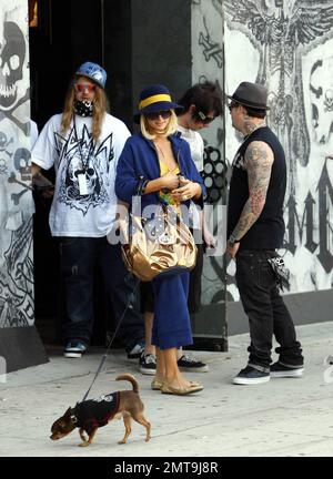 Una di queste cose non è come le altre! Paris Hilton, con il suo piccolo cane al traino, sembra un po' fuori posto con il suo abito colorato e il grande cappello blu mentre lei e il ragazzo Benji Madden fanno una sosta per fare shopping al negozio Benji, il DCMA Collective. Hollywood, California. 5/20/08. Foto Stock