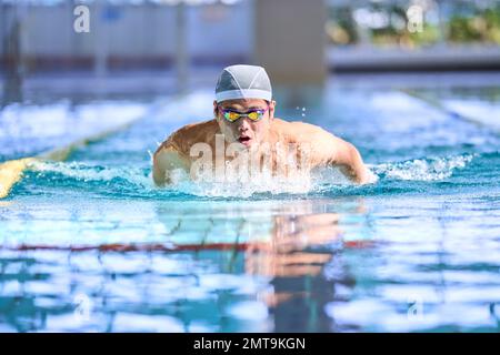 Atleta giapponese che nuota nella piscina coperta Foto Stock