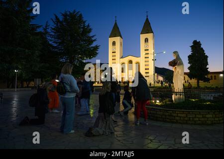 La gente prega intorno alla statua della Regina della Pace vicino alla Chiesa di San Giacomo a Medjugorje, Bosnia-Erzegovina. Foto Stock