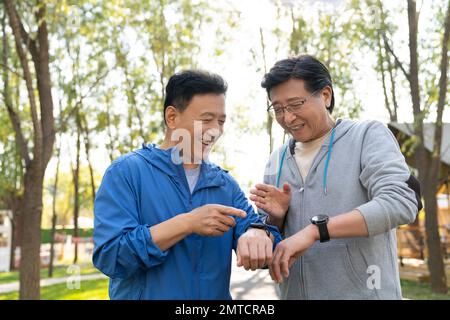 I due movimenti degli uomini più anziani guardano l'orologio sportivo Foto Stock