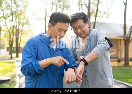 I due movimenti degli uomini più anziani guardano l'orologio sportivo Foto Stock