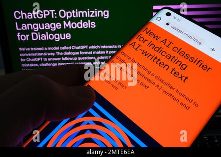 Pagina Web del software ai Text Classifier visualizzata sullo schermo dello smartphone e sulla pagina ChatGPT sullo sfondo sfocato. Strumento per il rilevamento di testo scritto ai tramite OPEN A. Foto Stock