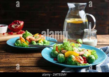 Gustosa insalata con germogli di Bruxelles servita su un tavolo di legno Foto Stock