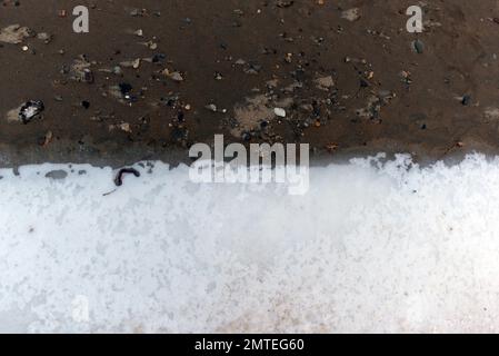 La consistenza dell'acqua mista del fiume e la neve bianca con ghiaccio nel pomeriggio d'inverno. Sfondo Foto Stock