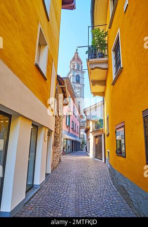 La stretta strada pedonale nella città vecchia con piccoli negozi, caffè e l'alta torre dell'orologio in pietra di San Pietro e Chiesa di San Paolo, che domina lo skyline, ASC Foto Stock