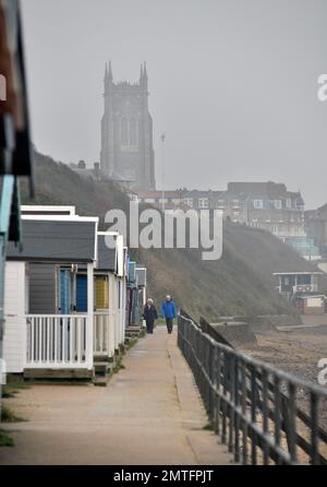 misty giorno noioso con la coppia più anziana a piedi sul lungomare cromer, cromer nord norfolk inghilterra Foto Stock