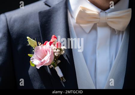 Dormagen, Germania. 06th ago, 2022. Decorazioni floreali appendono alla giacca dello sposo prima dell'inizio di una cerimonia nuziale. Credit: Silas Stein/dpa/Alamy Live News Foto Stock