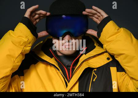 Uomo che indossa abiti sportivi invernali su sfondo nero Foto Stock