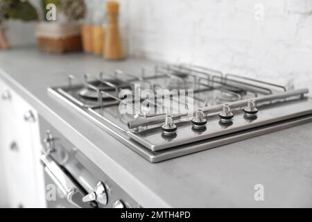 Nuova stufa moderna con bruciatori a gas in cucina, primo piano Foto Stock