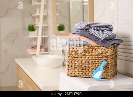 Cestino di vimini con vestiti sporchi sul pavimento nella lavanderia,  spazio per il testo Foto stock - Alamy