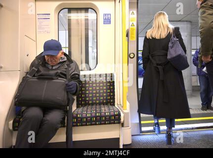 Londra, Inghilterra, Regno Unito. London Underground: Giovane donna e uomo anziano in una carrozza metropolitana Foto Stock