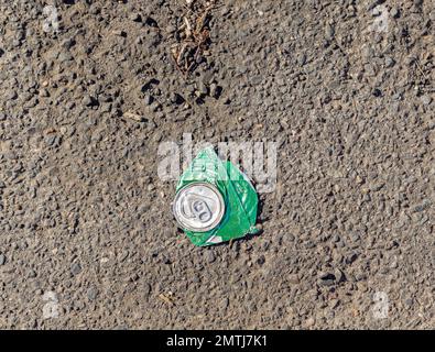 Una lattina di Sprite appiattita su una strada asfaltata Foto Stock