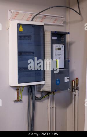 Brecht, Belgio - 26 januari 2023: Ritratto di un nuovo contatore elettrico digitale belga installato chilowattora accanto a una scatola fusibili con alcuni elettrici Foto Stock
