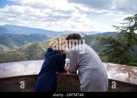 felice giovane coppia in piedi faccia a faccia sulla piattaforma di osservazione in montagna. Camminate insieme, godetevi il momento, le sensazioni teneri, la gioventù. Il fine settimana Foto Stock