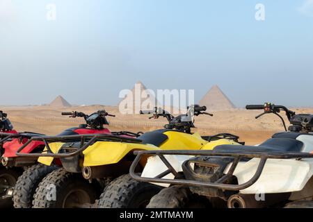 Quad colorati parcheggiato safari ATV nel deserto con piramidi sullo sfondo Cairo, Egitto. Nessuna gente Foto Stock