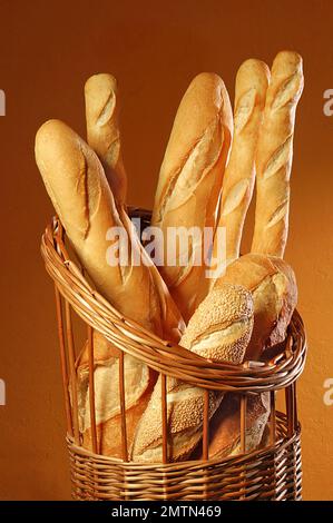 Vari tipi di pane in un cesto di vimini su uno sfondo di marmo. Foto Stock