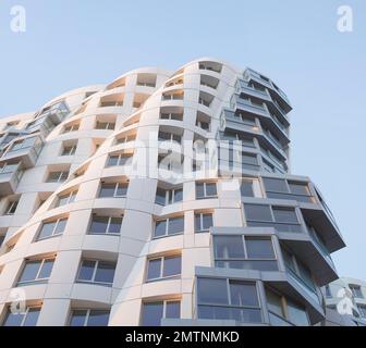 Guardando verso il cielo lungo la facciata bianca. Prospect Place Battersea Power Station Frank Gehry, Londra, Regno Unito. Architetto: Frank Gehry, 2022. Foto Stock