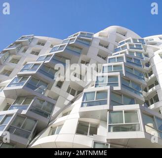 Guardando verso il cielo lungo la facciata bianca. Prospect Place Battersea Power Station Frank Gehry, Londra, Regno Unito. Architetto: Frank Gehry, 2022. Foto Stock
