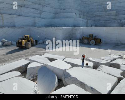 Pale gommate che lavorano su enormi cave di marmo. Foto Stock