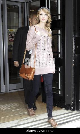 Durante la sua intensa visita a Londra, Taylor Swift indossa un maglione rosa, un cappello a maglia grigio e delle scarpe marrone molto blando mentre paga un'altra visita a sorpresa alla BBC radio 2. Londra, Regno Unito. 10/22/10. Foto Stock