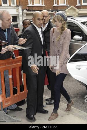 Durante la sua intensa visita a Londra, Taylor Swift indossa un maglione rosa, un cappello a maglia grigio e delle scarpe marrone molto blando mentre paga un'altra visita a sorpresa alla BBC radio 2. Londra, Regno Unito. 10/22/10. Foto Stock