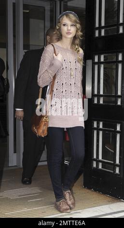 Durante la sua intensa visita a Londra, Taylor Swift indossa un maglione rosa, un cappello a maglia grigio e delle scarpe marrone molto blando mentre paga un'altra visita a sorpresa alla BBC radio 2. Londra, Regno Unito. 10/22/10. Foto Stock