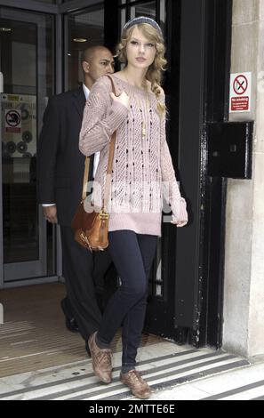 Durante la sua intensa visita a Londra, Taylor Swift indossa un maglione rosa, un cappello a maglia grigio e delle scarpe marrone molto blando mentre paga un'altra visita a sorpresa alla BBC radio 2. Londra, Regno Unito. 10/22/10. Foto Stock