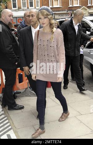 Durante la sua intensa visita a Londra, Taylor Swift indossa un maglione rosa, un cappello a maglia grigio e delle scarpe marrone molto blando mentre paga un'altra visita a sorpresa alla BBC radio 2. Londra, Regno Unito. 10/22/10. . Foto Stock