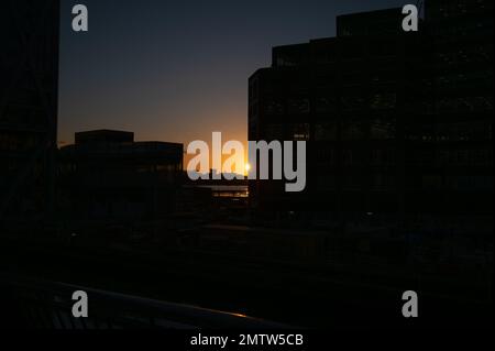 Silhouette degli edifici di Canary Wharf con tramonto sullo sfondo Foto Stock