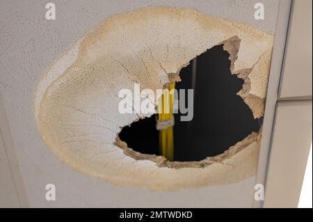 Un foro aperto nel soffitto causato da un danno all'acqua. Foto Stock