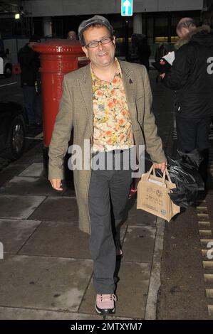 '80s e '90s il presentatore televisivo per bambini Timmy Mallett sorride mentre lascia la BBC radio 2 indossando un outfit in contrasto composto da una camicia floreale arancione e gialla con motivi floreali, pantaloni a righe e scarpe rosa. Londra, Regno Unito. 11/5/10. Foto Stock