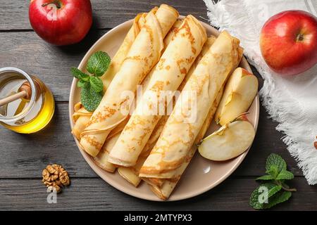 Deliziosi pancake sottili su tavolo di legno, piatto Foto Stock