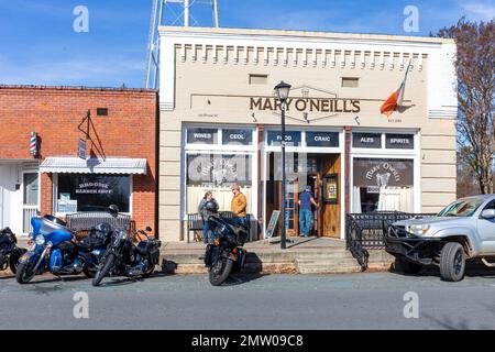 WAXHAW, NC, USA-28 GEN 2023: Mary o'Neill's Bar and Cafe. Motociclette parcheggiate davanti, patron che entra, e due persone che parlano sul marciapiede. Foto Stock