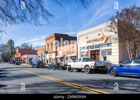 WAXHAW, NC, USA-28 GEN 2023: Vista lungo North Main St. Il sole del sabato invernale. Mary o'Neill's con motociclette parcheggiate davanti, persone sul marciapiede. Foto Stock