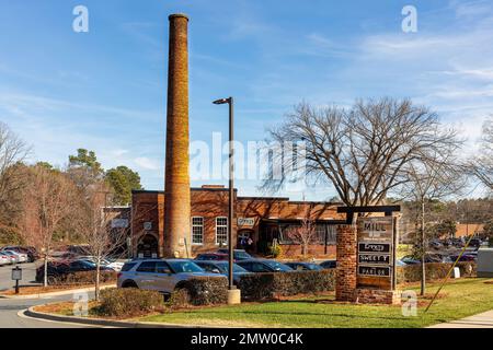 WAXHAW, NC, USA-28 GEN 2023: Vecchio mulino con ciminiera convertito in impianto di uso misto, 'il mulino sul principale'. Foto Stock