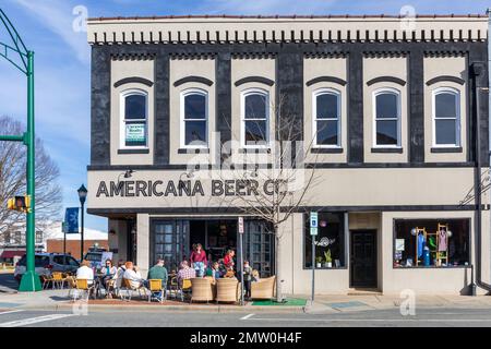 MONROE, NC, USA-28 GEN 2023: American Beer Co., un ristorante in centro, con i clienti ai tavoli del marciapiede. Adulti e bambini. Foto Stock