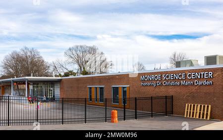 MONROE, NC, USA-28 GEN 2023: Monroe Science Center, retro dell'edificio con insegna e veranda coperta, adulti e bambini. Foto Stock