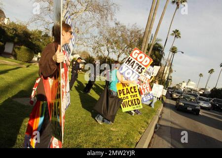 I membri della Westboro Baptist Church, conosciuta per le loro apparenti credenze anti-omosessuali e le loro attività di protesta, hanno dei segni dispregiativi mentre protestano dall'altra parte della strada rispetto all'hotel Beverly Hilton, dove si teneva la cerimonia annuale dei Golden Globe Awards 68th. Los Angeles, California. 01/16/11. Foto Stock