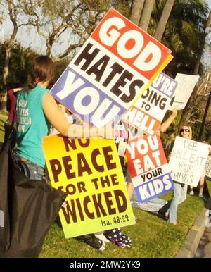 I membri della Westboro Baptist Church, conosciuta per le loro apparenti credenze anti-omosessuali e le loro attività di protesta, hanno dei segni dispregiativi mentre protestano dall'altra parte della strada rispetto all'hotel Beverly Hilton, dove si teneva la cerimonia annuale dei Golden Globe Awards 68th. Los Angeles, California. 01/16/11. Foto Stock