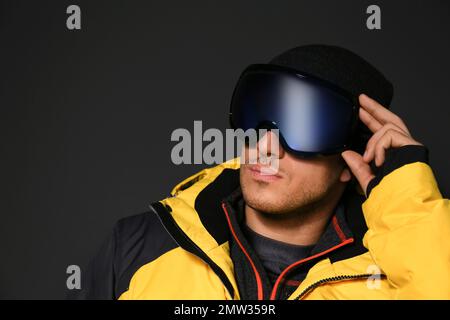 Uomo che indossa abiti sportivi invernali su sfondo nero Foto Stock