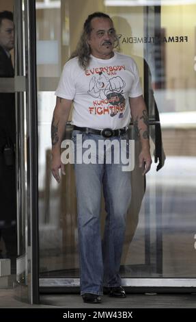 Il concorrente di 'X-Factor' Wagner Fiuza-Carrilho indossa una t shirt "Everybody was Kung-fu Fighting" mentre gioca un ruolo di scherzo su alcune giovani donne in una porta girevole in un edificio ITV. Londra, Regno Unito. 10/27/10. Foto Stock