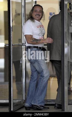 Il concorrente di 'X-Factor' Wagner Fiuza-Carrilho indossa una t shirt "Everybody was Kung-fu Fighting" mentre gioca un ruolo di scherzo su alcune giovani donne in una porta girevole in un edificio ITV. Londra, Regno Unito. 10/27/10. Foto Stock