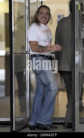 Il concorrente di 'X-Factor' Wagner Fiuza-Carrilho indossa una t shirt "Everybody was Kung-fu Fighting" mentre gioca un ruolo di scherzo su alcune giovani donne in una porta girevole in un edificio ITV. Londra, Regno Unito. 10/27/10. . Foto Stock